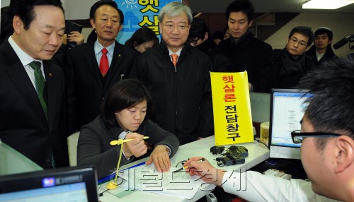 Financial Services Commission Chairman Kim Seok-dong (third from left) checks up on micro-loan products for the low- and middle-income brackets at the Korean Federation of Community Credit Cooperative in Seoul on Thursday. (Park Hyun-koo/Korea Herald)
