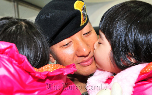 A soldier bids farewell to his twin daughters at a ceremony in Gwangju, Gyeonggi Province, on Monday to dispatch a South Korean contingent to the United Arab Emirates. (Kim Myung-sub/The Korea Herald)