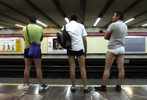 People wait for a subway train without trousers during an event 