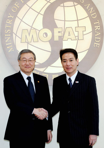 South Korean Foreign Minister Kim Sung-hwan, left, shakes hands with Japanese Foreign Minister Seiji Maehara at the joint news conference. (Yonhap News)