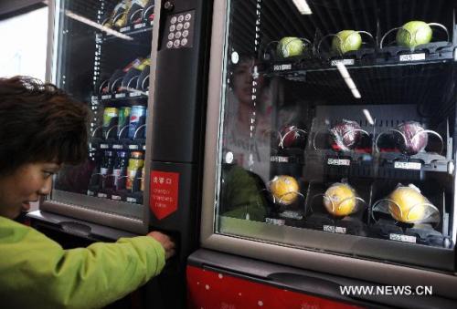 A passenger buys fruits in a vending machine at a subway station in Shanghai, east China, Jan. 17, 2011. Fruit vending machines have been placed in subway stations of Shanghai in recent days (Photo: Xinhua)