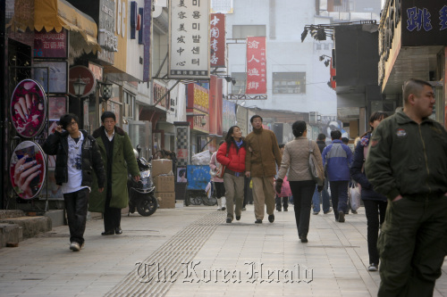 People walk along a shopping street in Beijing. (Bloomberg)