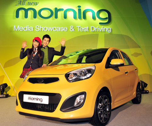 Models pose with Kia Motors Corp.’s new Morning city car at the launch ceremony in Jeju on Monday. (Kia Motors Corp.)