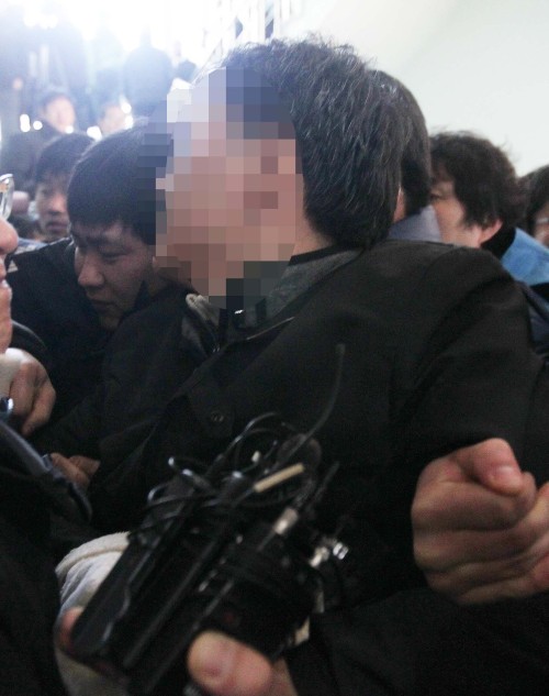A detective charged with killing his mother is taken into a police station in Daejeon on Friday. (Yonhap News)
