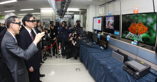 Prime Minister Kim Hwang-sik watches the 3-D moving pictures service demonstration at the 4G telecommunications technology briefing session in Daejeon last month. (Yonhap News)