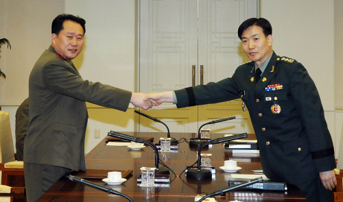 South Korea's Col. Moon Sang-gyun (right) and his North Korean counterpart Col. Ri Son-kwon shake hands at the beginning of the inter-Korean military talks at the border village of Panmunjeom on Tuesday. Yonhap News