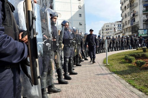 Riot police stand guard as Algerian pro-opposition protesters gather at a rally in Algiers.(Xinhua-Yonhap News)