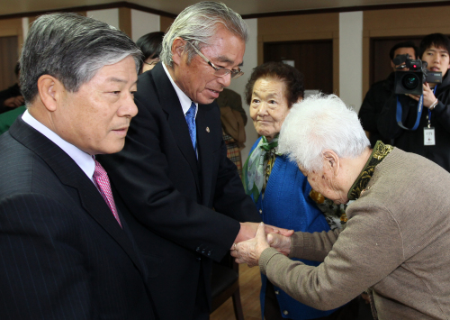 Former Korean Justice Minister Kim Sungho (left) and former Japanese Justice Minister Sugiura Seikan solace comfort women forced into sexual slavery for the Japanese troops during World War II at the House of Sharing in Gwangju, Gyeonggi Province, Sunday. (Yonhap News)