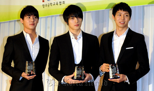 JYJ members Kim Jun-su (left), Kim Jae-joong (center) and Park Yoo-chun hold commemorative plaques at the appointment ceremony as goodwill ambassadors for the robot competition FLL KOREA in Seoul on Thursday. (Park Hyun-koo/The Korea Herald)