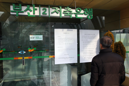 A depositor at a Busan Ⅱ Savings Bank in Busan is reading a suspension notice. S.Korea's financial regulator suspended four saving banks' operations on Saturday due to their insufficient liquidity. (Yonhap News)