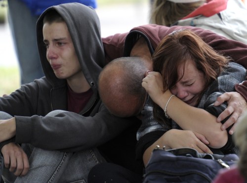 Fifteen-year-old Kent Manning, left, and his sister Libby, 18, react with their father, who asked not to identified, after they were told by police that there was no hope of finding Kent and Libby's mother alive in a collapsed building following a 6.3-magnitude earthquake Tuesday, in Christchurch, New Zealand, Wednesday, Feb. 23, 2011. (AP-Yonhap)