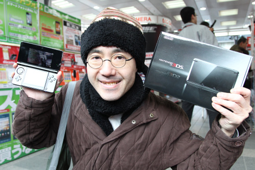 Customer Toyohisa Ishihara shows a Nintendo Co. 3DS handheld player after purchasing it at a Bic Camera Inc. electronics store in Tokyo, Japan, on Saturday. (Bloomberg)
