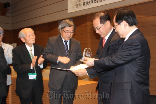Hwang Woo-yeo (second from right), head of a human rights forum of South Korean lawmakers, presents the National Assembly human rights award to Keni­chi Takagi, Japan, Friday. (Yonhap News)