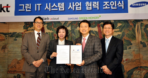 KT Corp.’s service innovation division head Song Jung-hee (second from left) and Samsung Electronics’ memory strategy marketing chief Hong Wan-hoon (second from right) pose after signing a deal to jointly develop the “Green IT System” in Seoul on Monday. (Samsung Electronics)