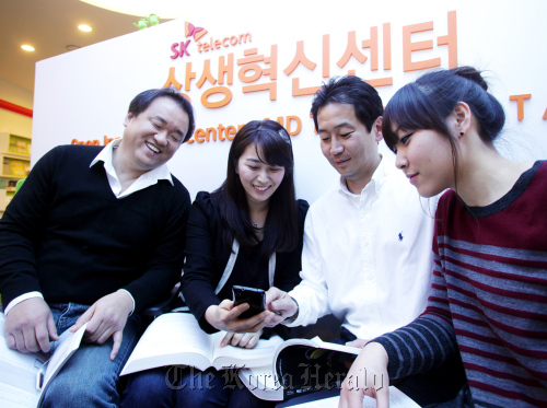 Developers from four member companies of SK Telecom’s Open API Collaboration Project converse at the company’s Open Innovation Center in Seoul on Monday.  (SK Telecom)