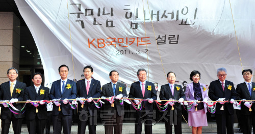 KB Financial Group chairman Euh Yoon-dae (fifth from right), KB Kookmin Card president and chief executive Choi Gi-eui (fourth from right), Kookmin Bank president and chief executive Min Byong-deok (third from left) and other executives cut the tape at the card unit’s launch at its headquarters in Seoul on Wednesday. (Kim Myung-sup/The Korea Herald)