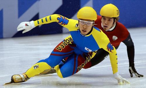 Kim Dong-sung, front, of South Korea, and Apolo Anton Ohno, of the United States, battle for position in the men's 1000-meter short track speedskating preliminary race in the Winter Olympics at the Salt Lake Ice Center in Salt Lake City, Wednesday, Feb. 13, 2002.(AP-Yonhap)