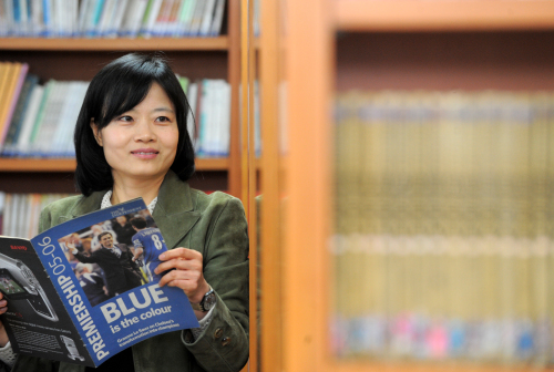 Hwang Sung-ah, English instructor for Dongguk University Middle School’s soccer team, with her teaching materials at the school library. (Ahn Hoon/The Korea Herald)