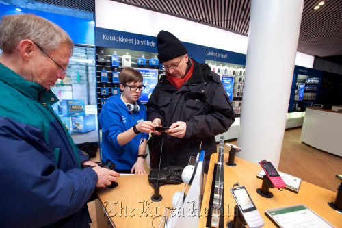 Customers look at Nokia Oyj E7 mobile handsets for sale in a Nokia store in Helsinki. (Bloomberg)
