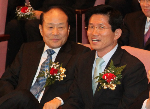 Gyeonggi Governor Kim Moon-su (right) sits with Rep. Lee Sang-deuk, an elder brother of President Lee Myung-bak, during an event in Seoul last week. (Yonhap News)