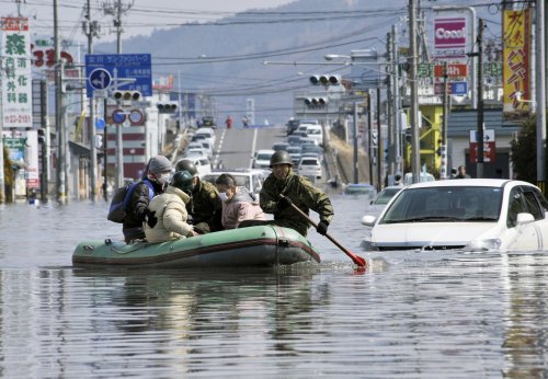 Members of Japan Self-Defense Forces rescue people stranded at a flooded city center in Ishinomaki, Miyagi Prefecture, northern Japan. (AP-Yonhap News)
