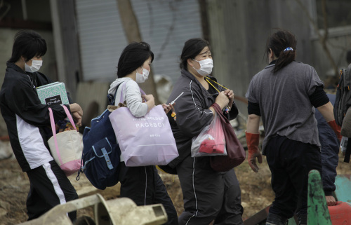 People walk out of their town after retrieving belongings at their homes in Daigasaki, near Sendai, northern Japan. (AP-Yonhap News)