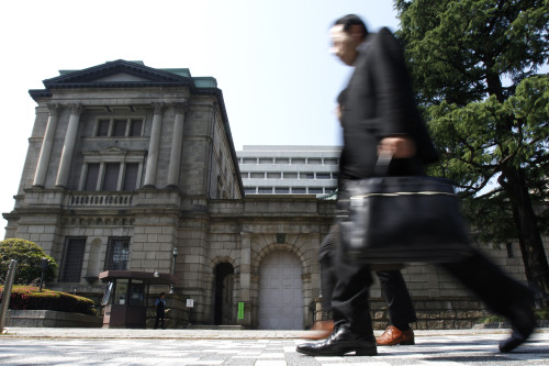 Pedestrians walk past the Bank of Japan headquarters in Tokyo. (Bloomberg)