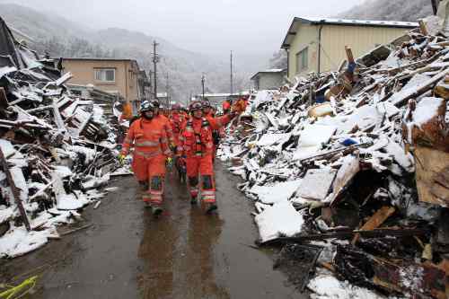 Members of a British search and rescue team begin their search for trapped people as snow falls in Kamaishi, Japan, Wednesday, March 16, 2011. Two search and rescue teams from the U.S. and a team from the U.K. with combined numbers of around 220 personnel searched the town for survivors Wednesday to help in the aftermath of the earthquake and tsunami. (AP-Yonhap)