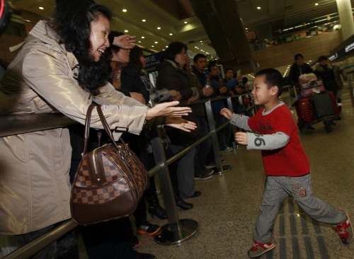 A mother greets her child departed from Japan at an airport in Shanghai, east China, March 17, 2011. A flight carrying a total of 298 Chinese passengers arrived in Shanghai on Thursday morning. China is rapidly withdrawing its nationals from the areas worst hit by a devastating earthquake and ensuing tsunamis in Japan as severely damaged nuclear power plants there are posing a safety threat. (Xinhua-Yonhap News)