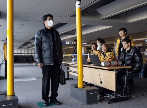 A passenger from Japan passes through a scanner to check radiation level at Incheon international airport, west of Seoul Thursday, March 17, 2011. (AP-Yonhap News)