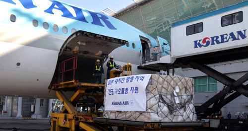 Korean Air employees at Incheon International Airport on Thursday load a plane with blankets, water and other relief supplies to be flown to the quake and tsunami victims in Japan. (Yonhap News)