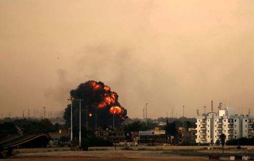 Smoke billows after a Libyan jet bomber crashed after being shut down in Benghazi on Saturday as Libya's rebel stronghold came under attack, with at least two air strikes and sustained shelling of the city's south sending thick smoke into the sky. (AFP-Yonhap News)