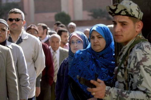 An Egyptian soldier stands guard as voters queue outside a polling station in Mansura, 120 km north of Cairo, on Saturday. (AFP-Yonhap News)