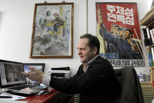 Nicholas Bonner, an owner of the Koryo tour agency, shows off snapshots from North Korean daily life at his office in Beijing. (AFP-Yonhap News)