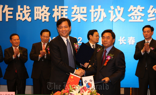 KT&G Corp. president Min Young-jin (front row, right) shakes hands with Jilin Province Vice Governor Chen Weigen after signing a memorandum of understanding in China on Tuesday. (KT&G)