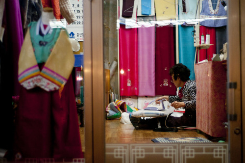 A woman works in a hanbok shop near Saejeol Station.