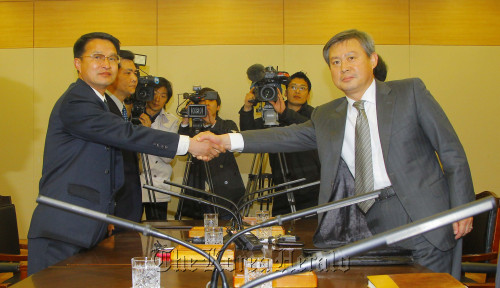 Chief South Korean delegate Yoo In-chang (right) shakes hands with his North Korean counterpart Yun Yong-geun as they start a meeting in Munsan, south of the inter-Korean border, Tuesday, on a North Korean volcano’s possible eruption. (Park Hae-mook/The Korea Herald)