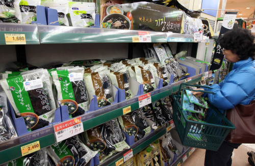 A customer takes dried seaweed at a local discount store. (Yonhap News)