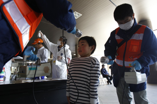 A young boy is screened for radiation contamination before entering an evacuation center in Fukushima, Japan, Friday. (AP-Yonhap News)