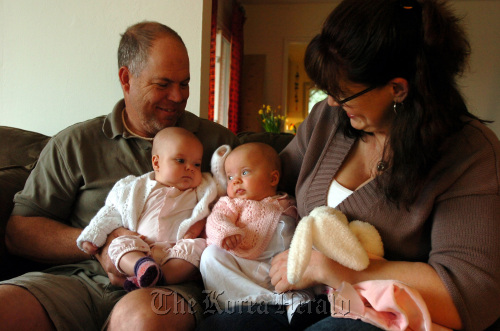 Mike Rose (left) holds daughter Sophia as Stephanie Lovell-Rose holds Sophia’s twin sister Allison at home in El Cerrito, California, March 24. (Contra Costa Times/MCT)