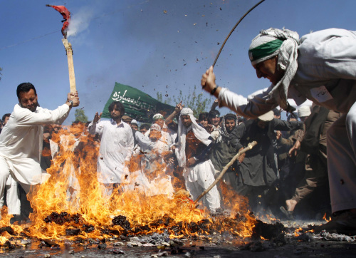 Afghan protestors beat a burning effigy of U.S. President Barack Obama during a demonstration in Jalalabad, Afghanistan on Sunday. (AP-Yonhap News)