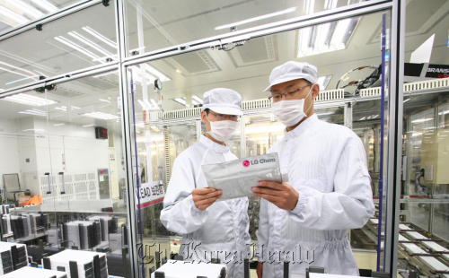 LG Chem employees examine products at the firm’s electric car battery plant at Ochang, North Chungcheong Province. (LG Chem)