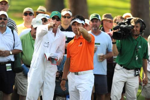 Yang Yong-eun and his caddie Michael Bestor discuss options from the rough on the 17th hole during the first round of the Masters golf tournament at Augusta National Golf Club in Augusta, Georgia, Thursday. (AFP-Yonhap News)