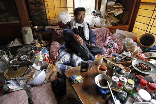 (Kunio Shiga listens to a battery-powered radio in the living room of his home in Minami Soma, Fukushima Prefecture, inside the deserted evacuation zone established for the 20 kilometer radius around the Fukushima Dai-ichi nuclear complex in northeastern Japan Friday, April 8, 2011. The 75-year-old man was stranded alone in his farmhouse ever since Japan's monstrous tsunami struck nearly a month ago. / AP-Yonhap News)