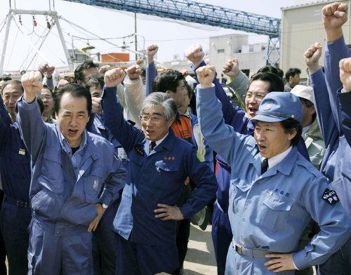 Japan’s Prime Minister Naoto Kan (left) shouts “Come on, Japan” along with Ishinomaki Mayor Hiroshi Kameyama (center) and other people as he visits Ishinomaki, a port town devastated by last month’s earthquake and tsunami in northeastern Japan, on Sunday. (AP-Yonhap News)