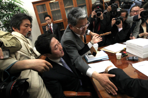 An opposition lawmaker (center) tries to block the subcommittee chairman's proceeding of the voting on the Korea-EU FTA ratification bill in the National Assembly on Friday. (Yonhap News)