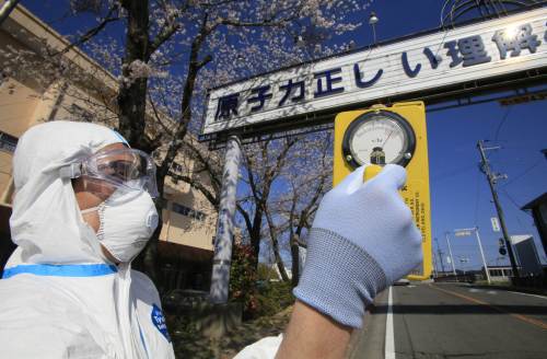 A man in a radiation-proof suit checks radiation level at Futaba town, Fukushima prefecture, within 10 kilometers of the stricken Tokyo Electric Power Co. Fukushima nuclear power plant. (AFP-Yonhap News)