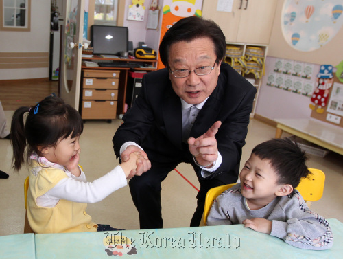 Kang Jae-sup of the ruling GNP speaks with a child at a child care facility in Bundang on Wednesday a week ahead of the by-election. (Yonhap News)