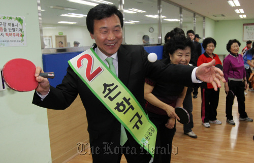 Sohn Hak-kyu, the DP’s candidate for the parliamentary by-election, plays table tennis with a citizen in a Bundang welfare center on Wednesday. (Yonhap News)