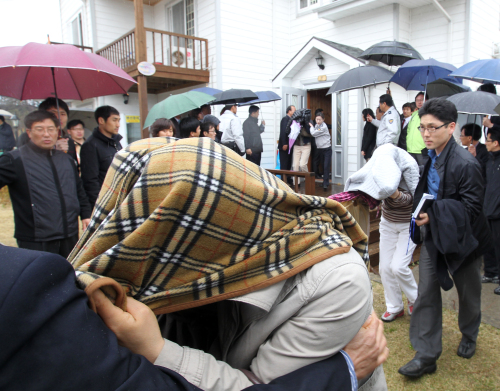 Police take people out of a pension in Gangneung on Friday where they allegedly campaigned illegally for Ohm Ki-young, the Gangwon gubernatorial candidate of the ruling GNP. (Yonhap News)